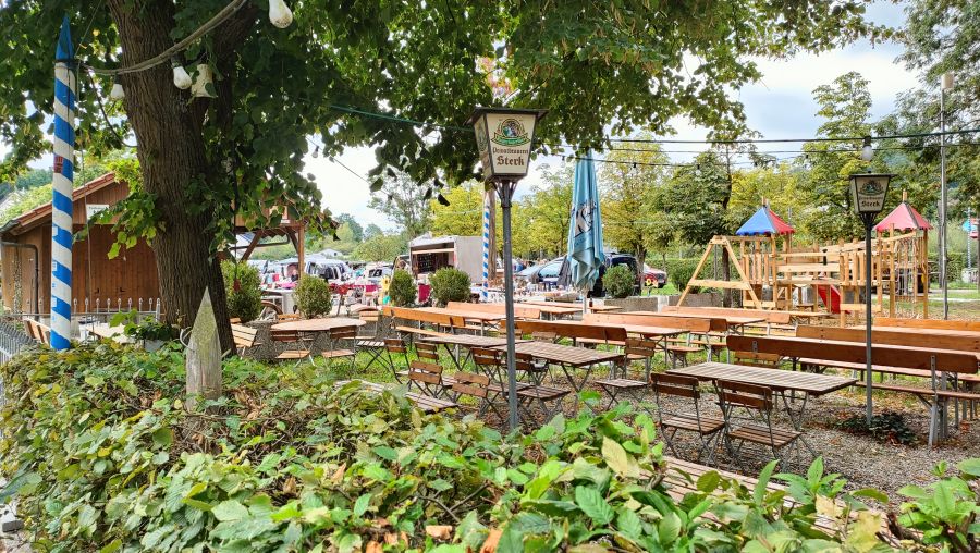 Biergarten der Privatbrauerei Sterk mit Maibaum und Kinderspielplatz, im Hintergrund die Stände des Flohmarkts Amberg-Raigering.