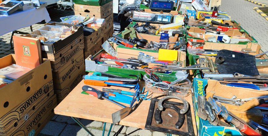 Mehrere Kisten voller gebrauchtem Handwerkzeug – Schraubenschlüssel, Zangen, Schraubendreher, Hämmer – auf einem Flohmarkt-Werkzeugstand.