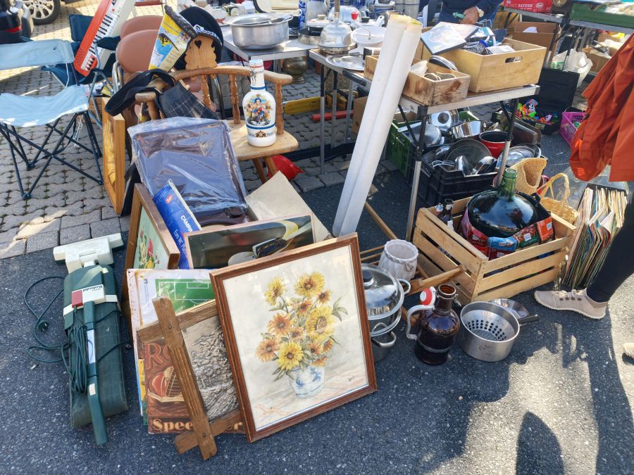Gerahmtes Sonnenblumen-Gemaelde und Geschirr als Flohmarkt-Angebot